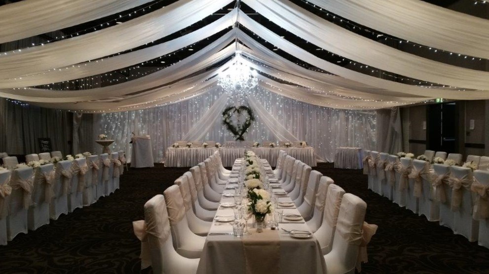 Champagne bows white long guest tables willow heart backdrop feature