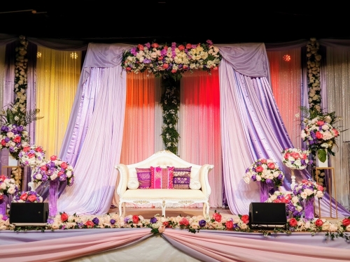 Indian Backdrop Stage lilac, white sequin, hot pink. pale pink, purple grouped floral arrangements