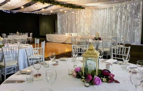 Jetty Harbour Rooms - Marquee ceiling canopy, greenery & wrought iron pendent lanterns spine, Tiffany chairs. daisy lanterns - Pacific Bay Resort