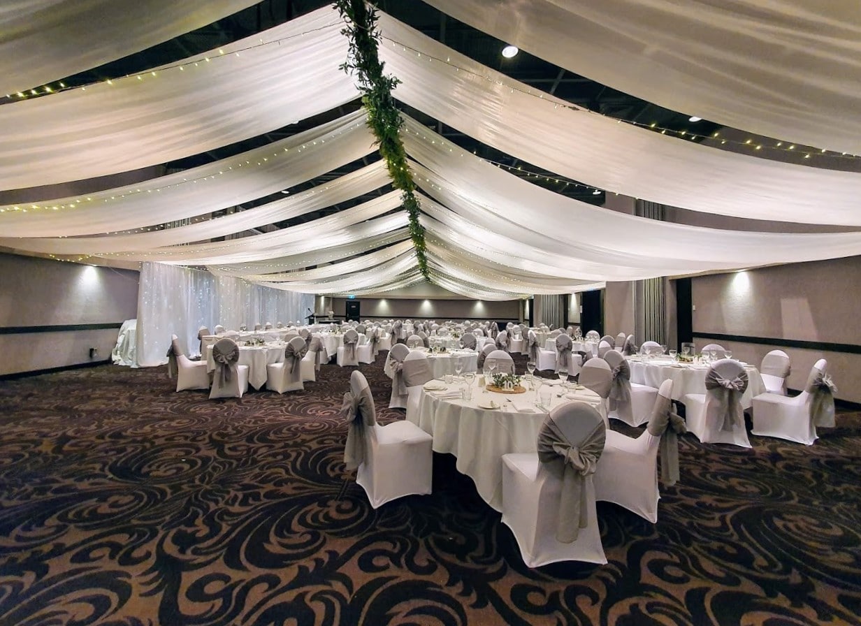 Backdrop to the side of room ceiling canopy marquee style greenery spine Opal Cove Ballroom