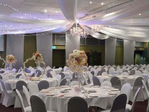 Star ceiling canopy white & fairy lights, crystal chandeliers, white chair covers, white silk wall drops