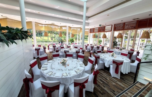 Bay side grill, white chair covers burgundy bows, Table decoration glass rose bowl silk white pale pink peonies, mercury tealights - Pacific Bay Resort