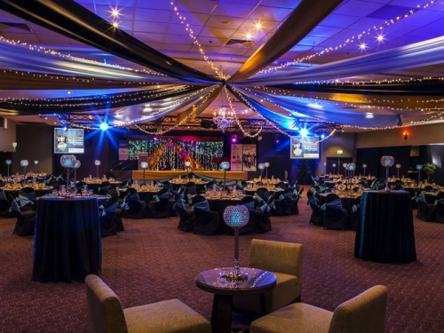 Star ceiling canopy black, gold & silver, crystal chandeliers, black chair covers aqua side tie sash  - Grand Auditorium Cex