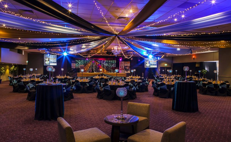 Star ceiling canopy black, gold & silver, crystal chandeliers, black chair covers aqua side tie sash  - Grand Auditorium Cex
