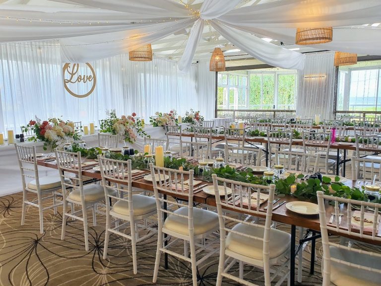 Timber toppers, white Tiffany chairs, glass cylinder vases with remote candle, white satin backdrop, star ceiling ceiling canopy, waterfall fairy lights (fresh florals not included)