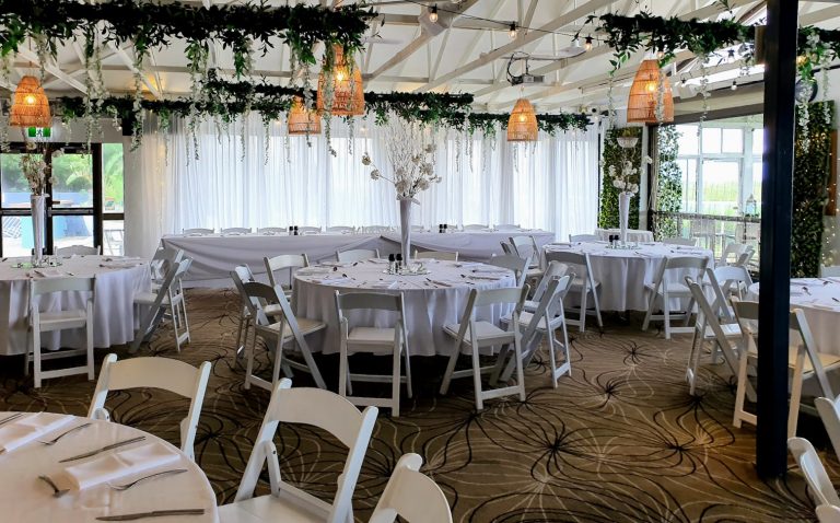 White full satin plain backdrop, Forest green framing, festoon lighting, Green ceiling bars with Wisteria, Waterfall fairy light curtain, white Malibu chairs, Round mirrors, tea lights, table numbers, Pilsner vase with white cherry blossom branches, bamboo fairy lights with white sash