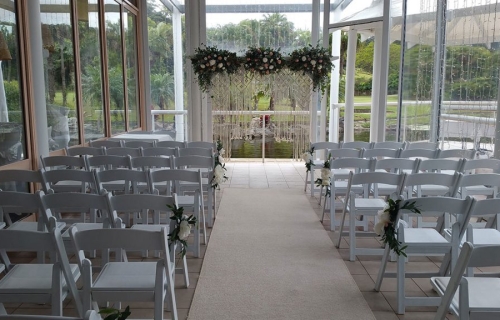 Wedding ceremony white timber arbour macramé rope fresh flowers Bay side lower deck Pacific Bay Resort