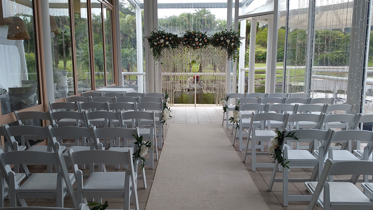Wedding ceremony white timber arbour macramé rope fresh flowers Bay side lower deck Pacific Bay Resort