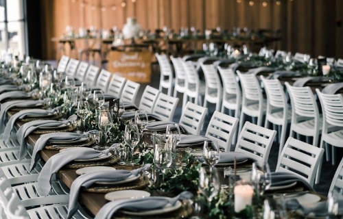 Woolgoolga surf  table décor ivy strings + babies breath, dove grey knot napkins, rattan placemats, timber table numbers white writing, glass cylinder vase + fresh pillar candle, timber topper tables